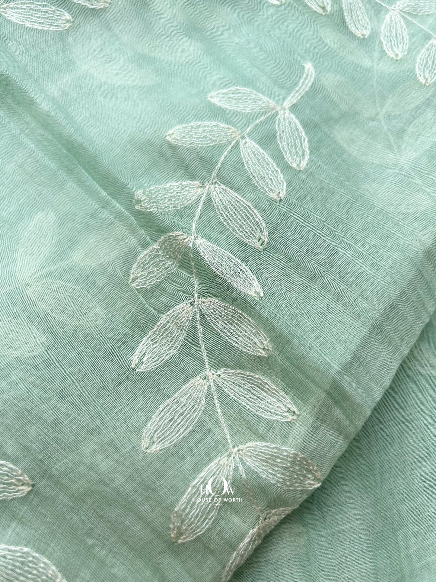 Subtle leaf embroidered Mul Chanderi fabric in mint shade – breathable and soft, sourced from Surat, Delhi, and Banaras.