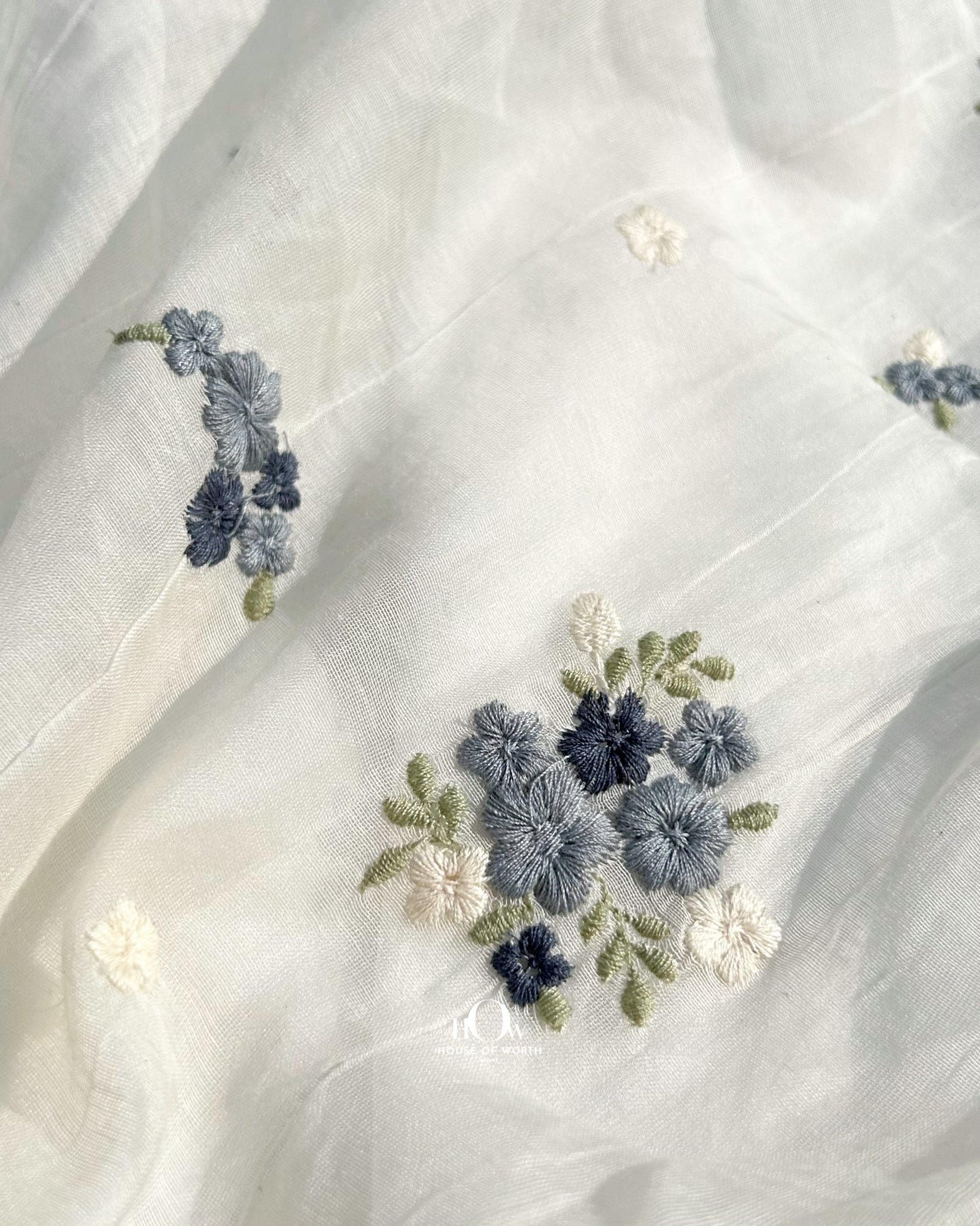 Buy embroidered Pure Mul Chanderi fabric in bulk – navy and sky blue threadwork on a soft dyeable base.