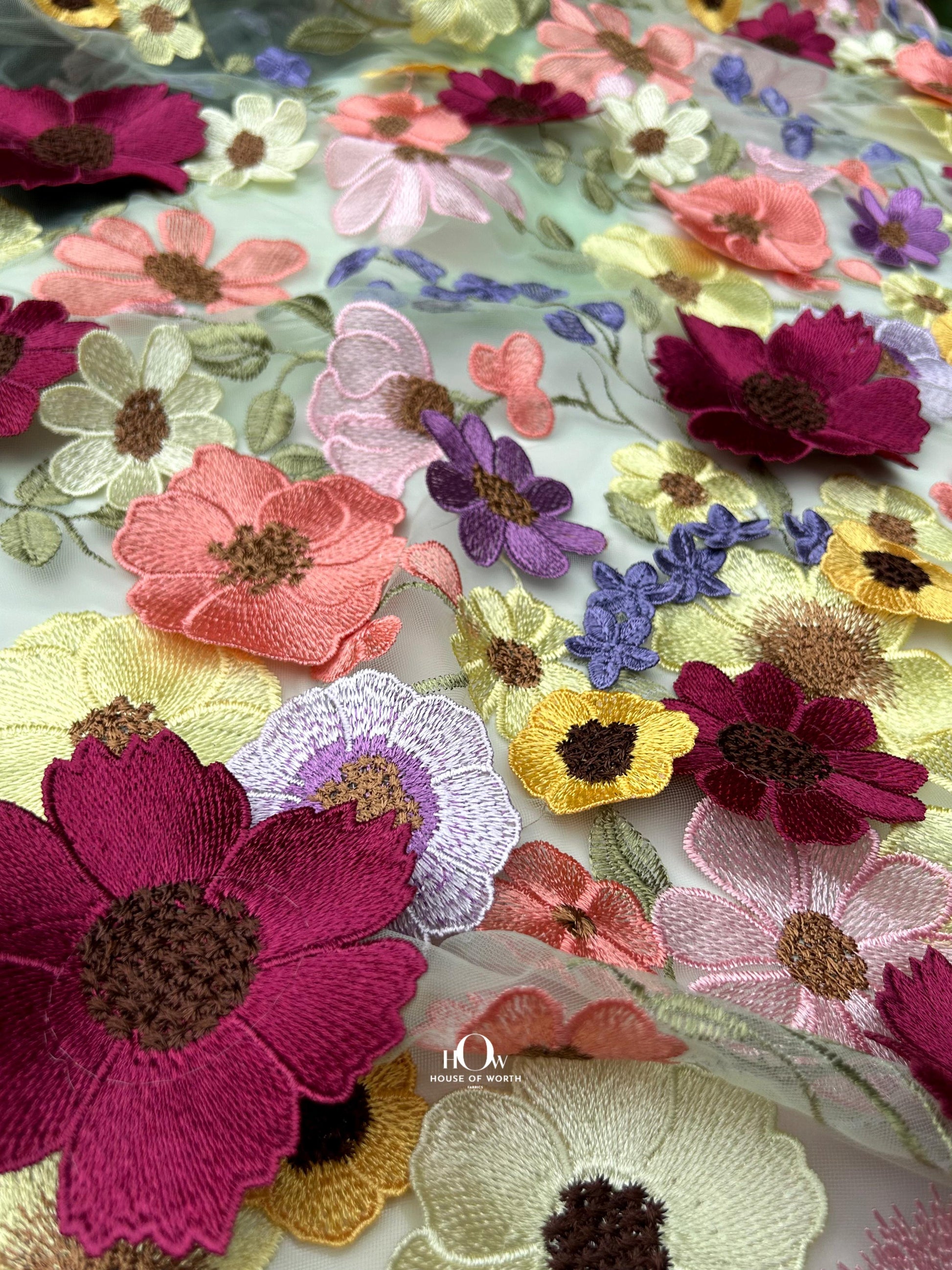 Luxury floral appliqué net – elegant bridal lehenga and gown textile.