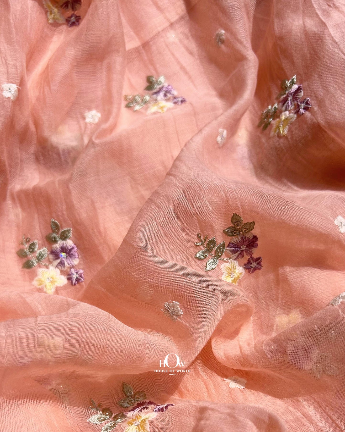 Buy floral embroidered Pure Mul Chanderi fabric in peach – lightweight and breathable fabric for retail and wholesale orders.