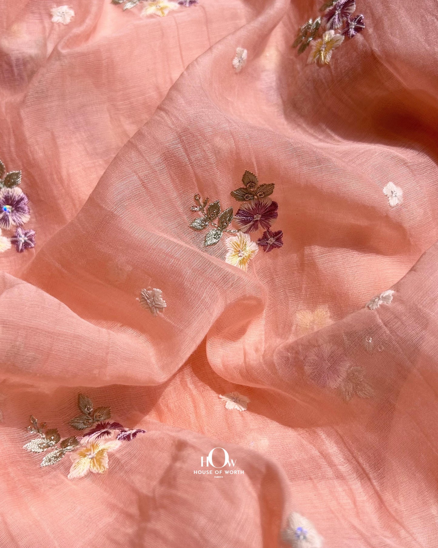 Peach Pure Mul Chanderi fabric with multicolor floral embroidery – perfect for sarees, suits, and ethnic collections.