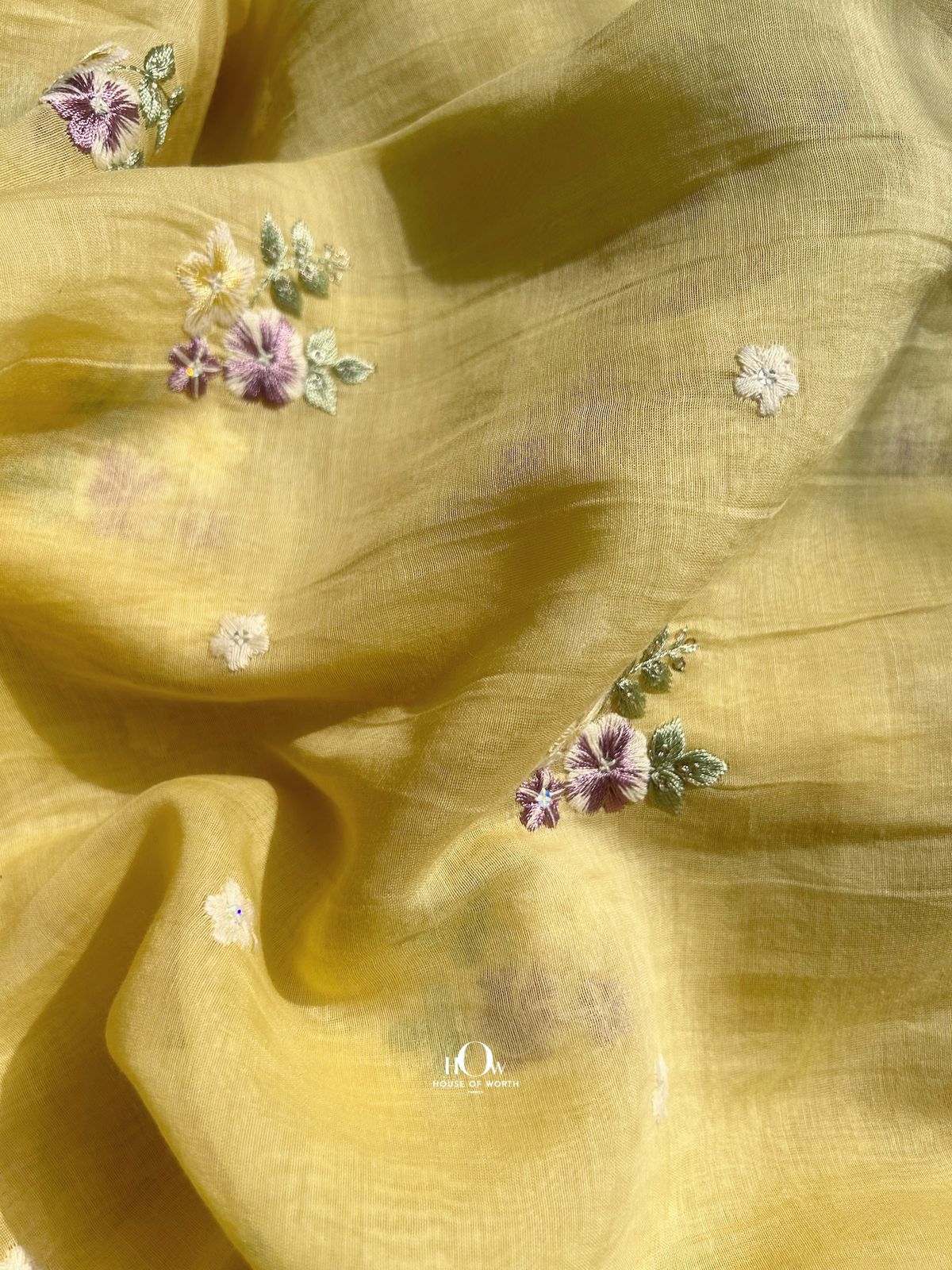 Handwoven yellow Mul Chanderi fabric with multi-color floral buttas – premium quality for boutique and occasion wear.