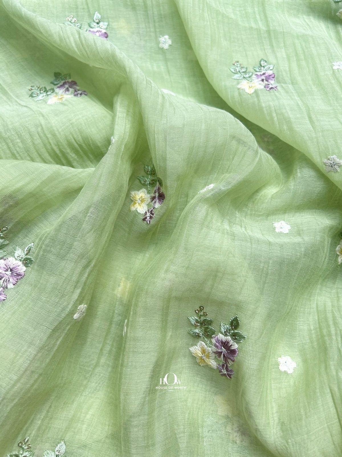 Soft handwoven Mul Chanderi fabric with floral threadwork – premium pistachio green base perfect for boutique tailoring.
