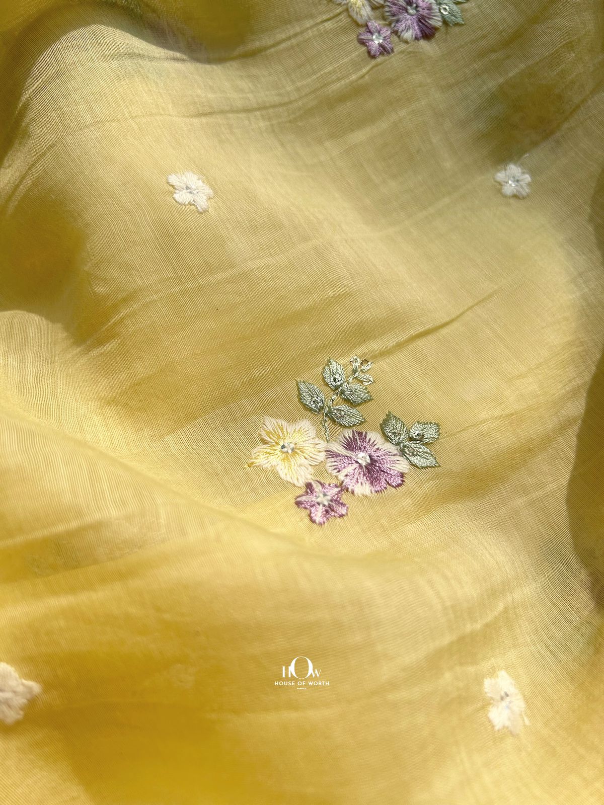 Yellow Mul Chanderi fabric for tailoring and retail – pastel floral motifs on breathable, semi-sheer fabric from Banaras and Surat.