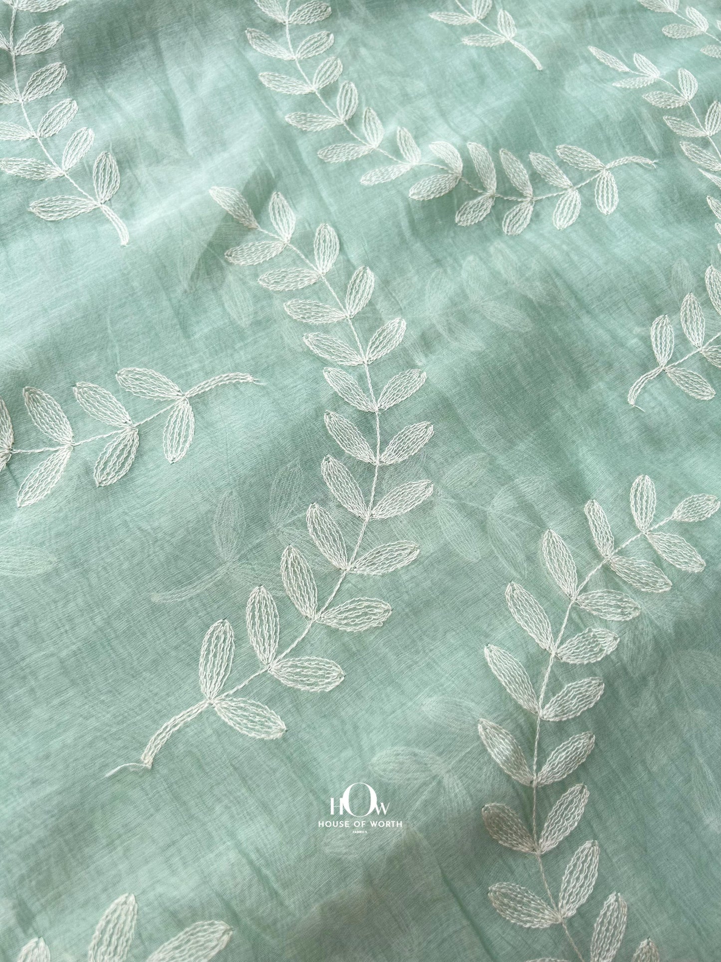 Premium pastel Mul Chanderi fabric with self-tone leaf embroidery – suitable for ethnic collections and festive wear.
