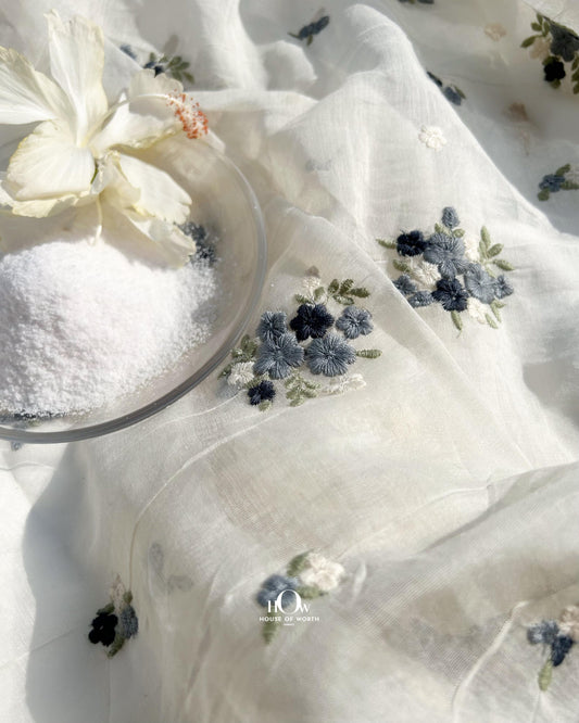 Dyeable off-white Pure Mul Chanderi fabric with blue floral butti embroidery – lightweight fabric for ethnic and festive wear.