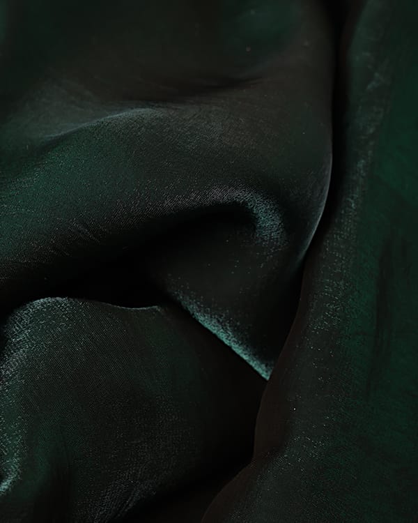 Rich emerald green imported glass chiffon fabric with a sheer, lightweight texture, draped elegantly for high-end gowns.