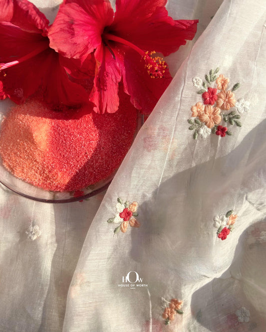 Pure dyeable Mul Chanderi fabric in off-white with red floral butti embroidery – ideal for sarees and ethnic suits.