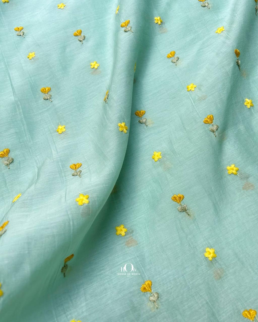 Breathable pastel aqua chanderi fabric embroidered with fine floral motifs.