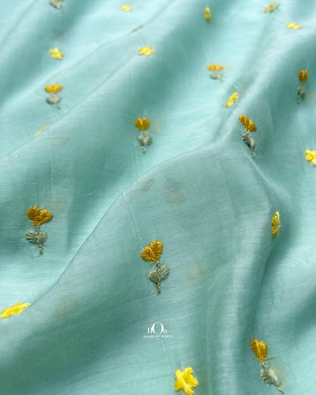 Lightweight pastel aqua chanderi fabric with subtle floral thread embroidery.