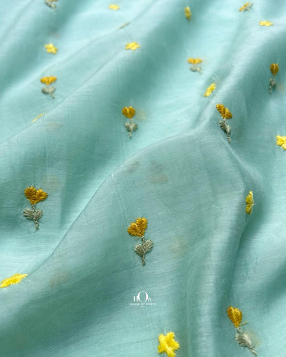 Lightweight pastel aqua chanderi fabric with subtle floral thread embroidery.