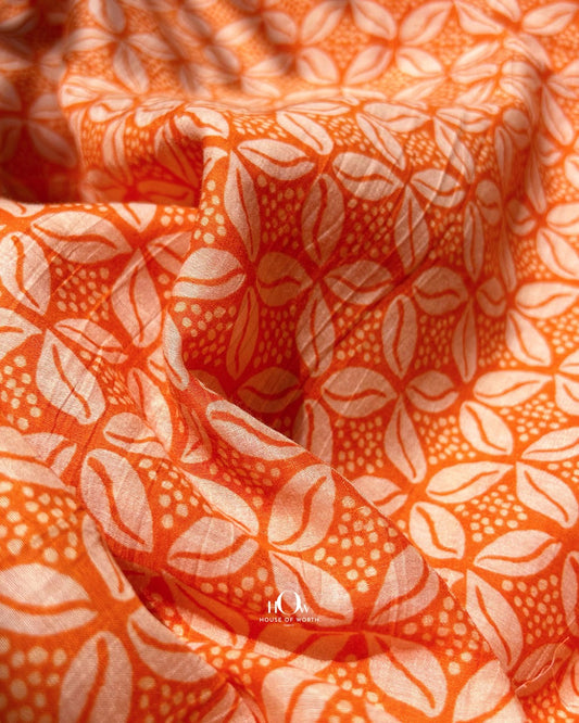 Orange printed Mul Chanderi fabric with abstract leaf design – lightweight handloom fabric for ethnic suits and sarees.