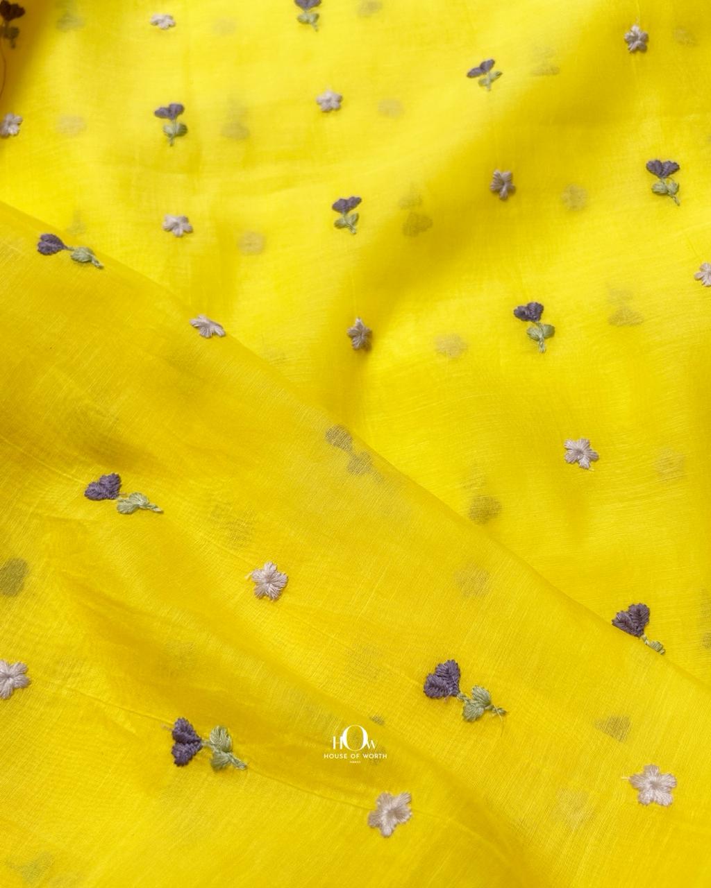Soft yellow chanderi fabric with warm-toned floral buti embroidery.
