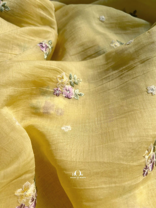 Bright yellow Pure Mul Chanderi fabric with pastel floral embroidery – perfect for festive sarees, kurtas, and suits.