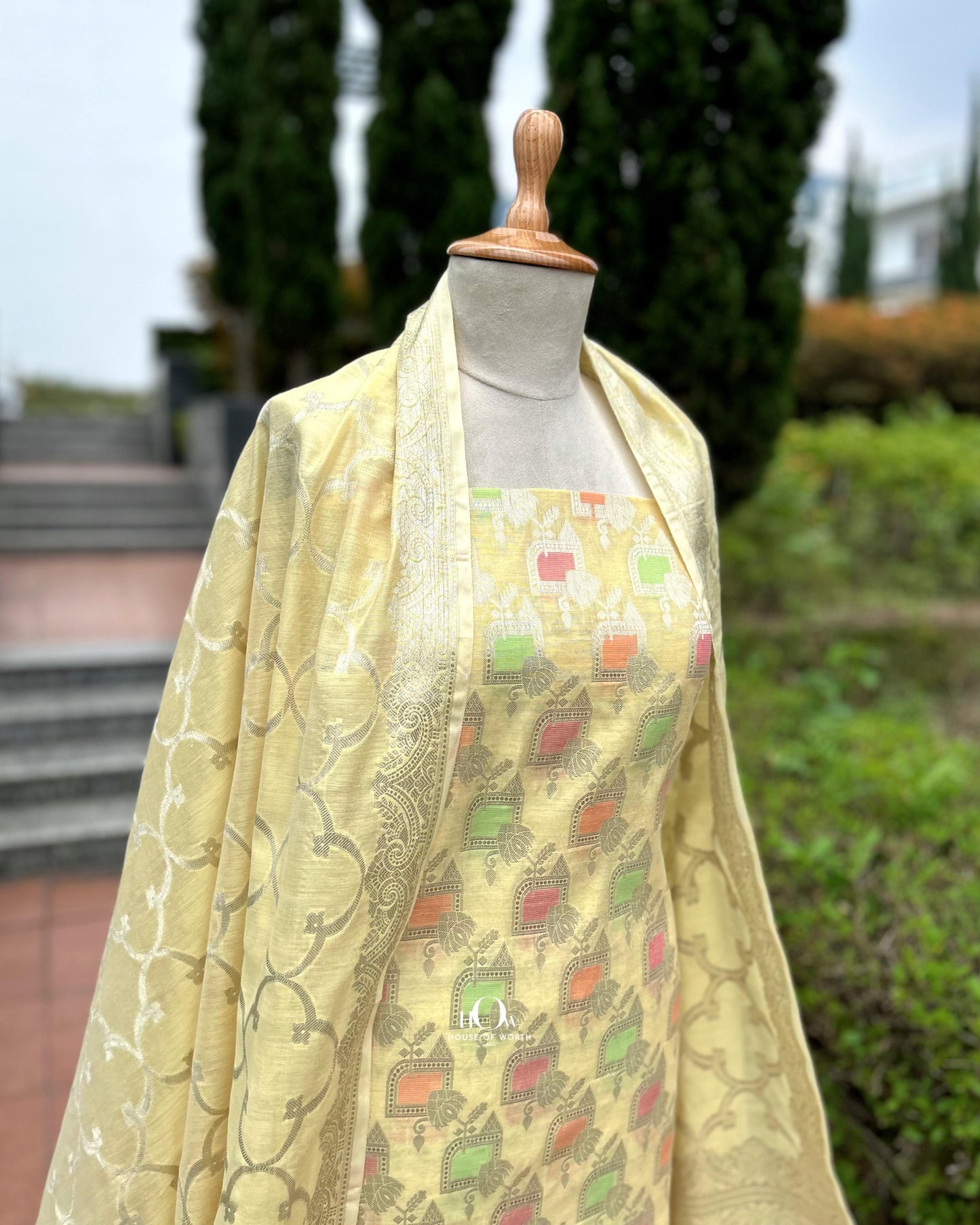 Lemon yellow cotton suit material with zari detailing for festive wear.