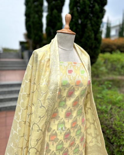 Lemon yellow cotton suit material with zari detailing for festive wear.