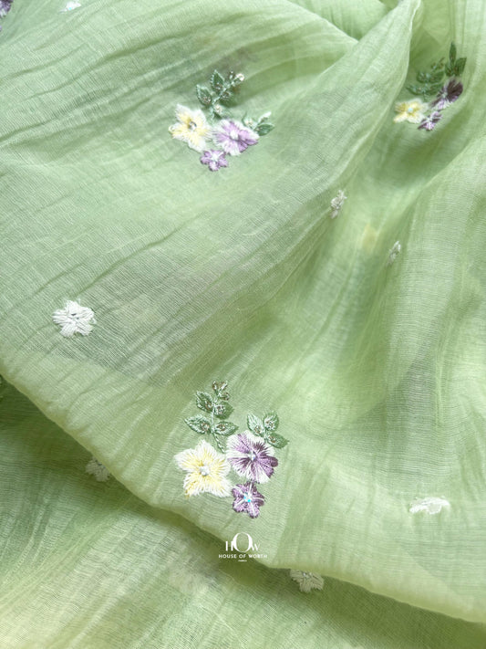 Pistachio green Pure Mul Chanderi fabric with pastel floral embroidery – ideal for sarees, salwar suits, and festive garments.