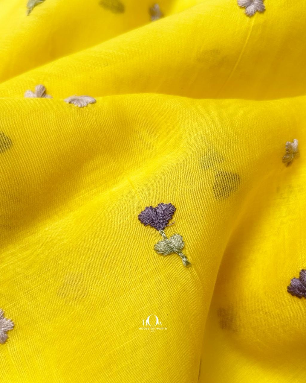Luxurious yellow pure mul chanderi fabric with delicate thread embroidery.