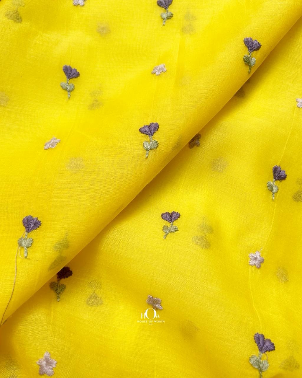 Breathable yellow chanderi fabric adorned with handcrafted floral motifs.
