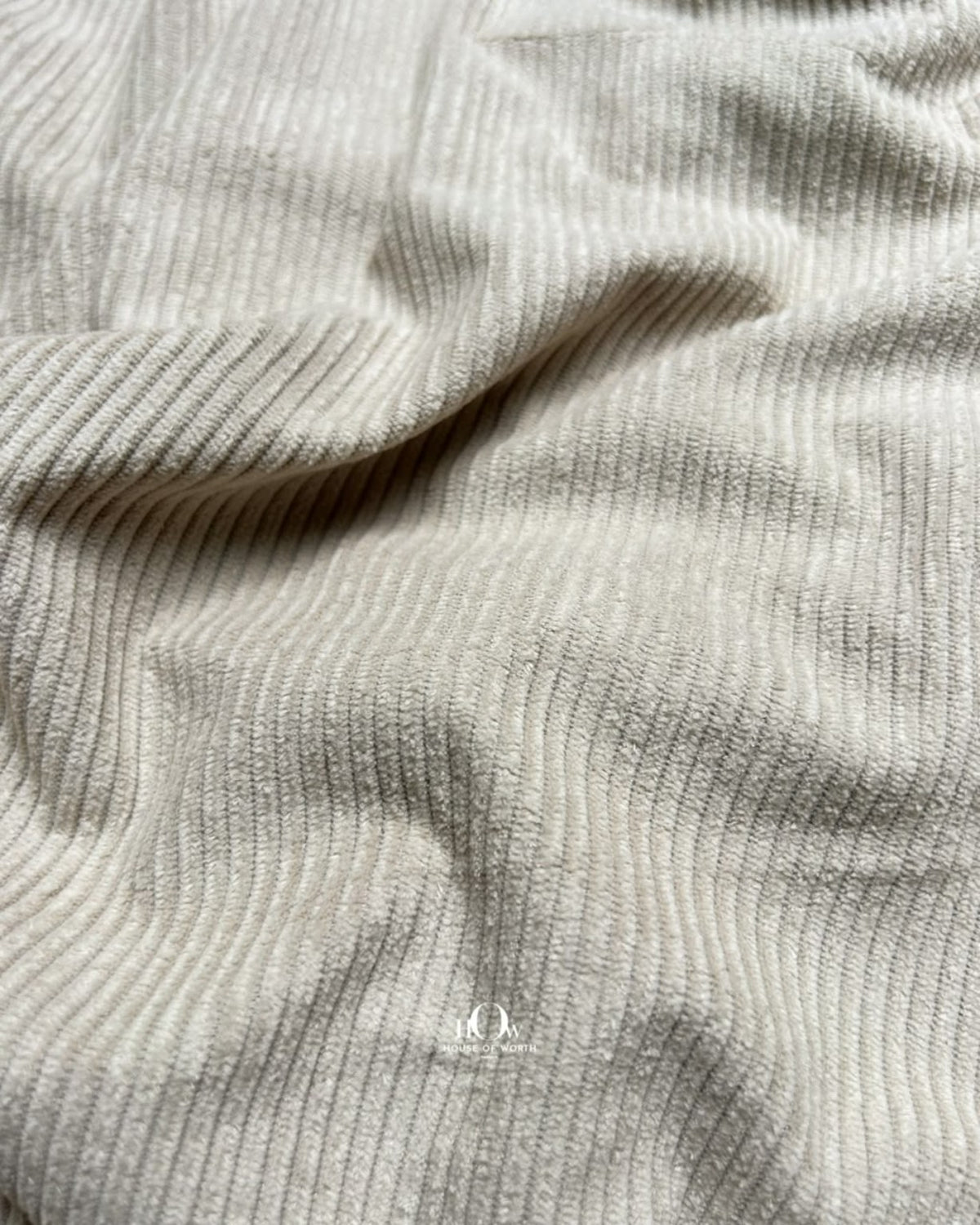 Beige corduroy fabric with neat linear ribbing and a clean neutral solid surface