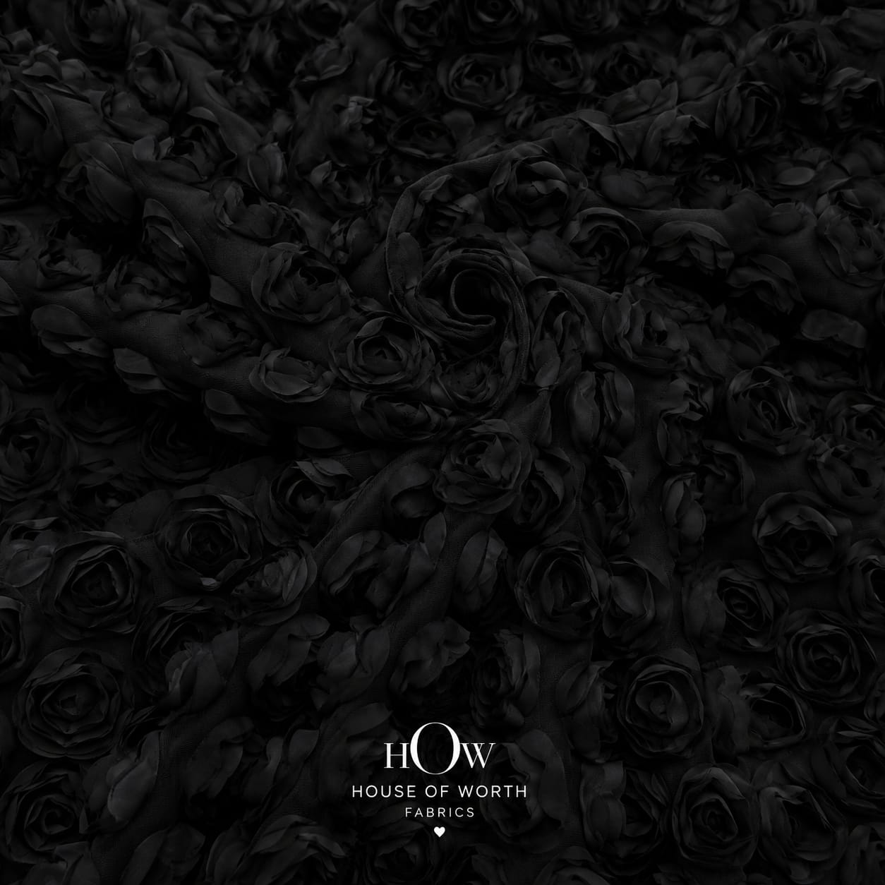 Close-up of black 3D flower applique net fabric with dimensional floral texture