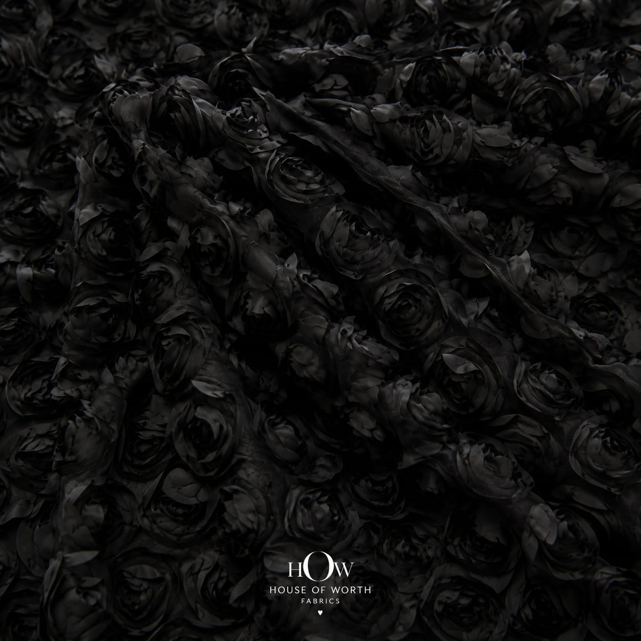 Black 3D floral applique fabric on net draped to show raised flowers