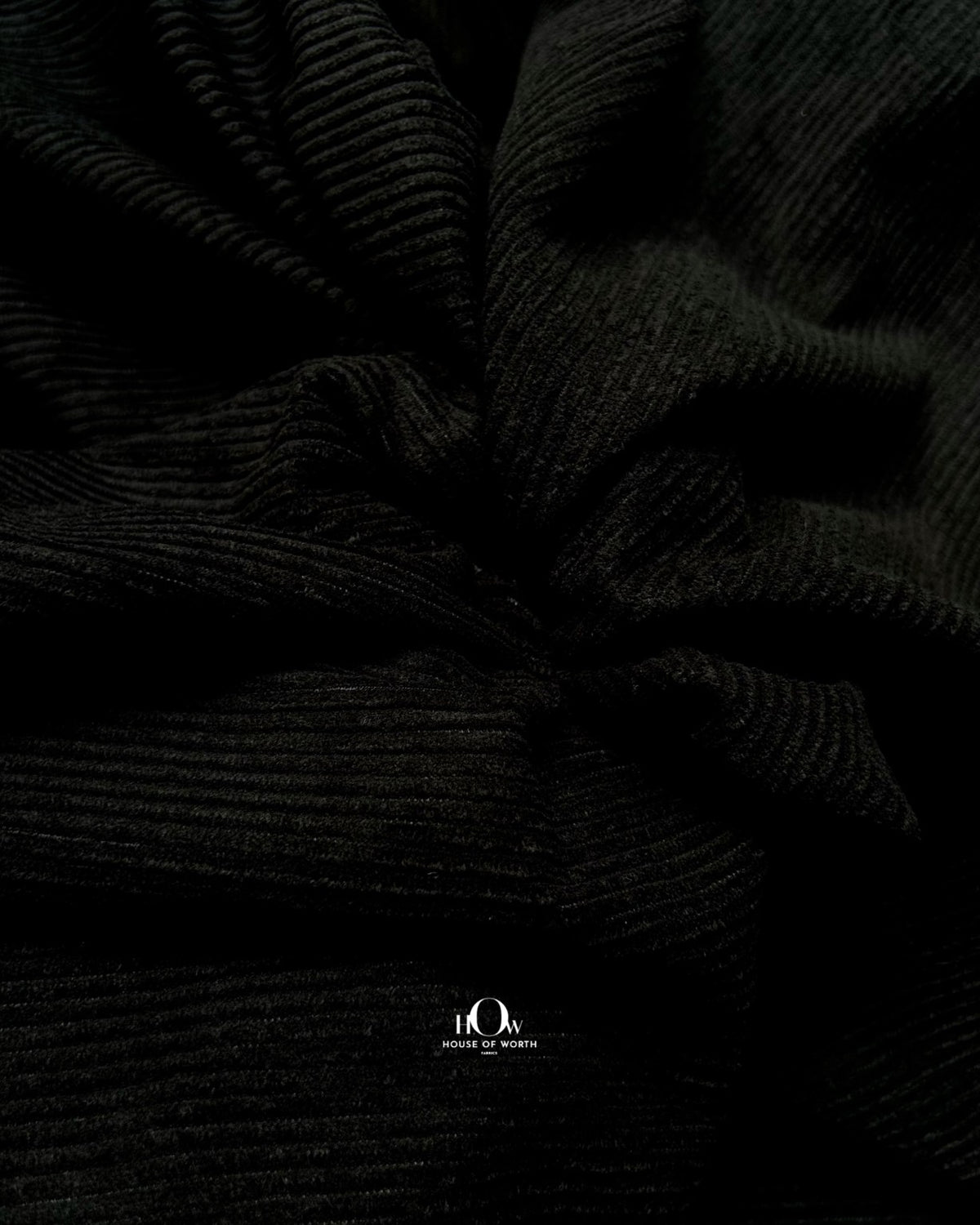 Black corduroy fabric with crisp linear ribbing and a clean solid black surface