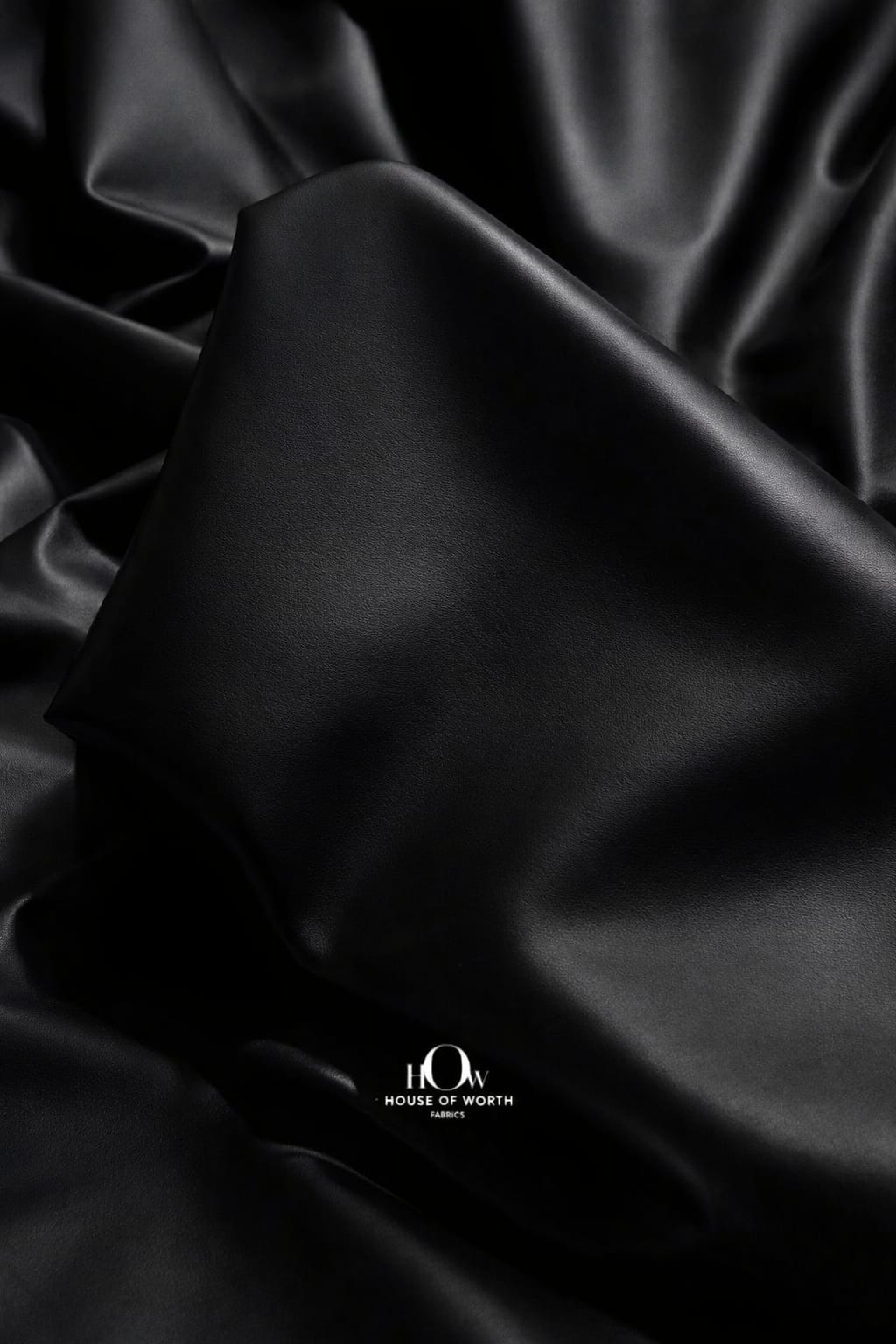 Black imported leather fabric close-up with smooth rich finish for luxury jackets