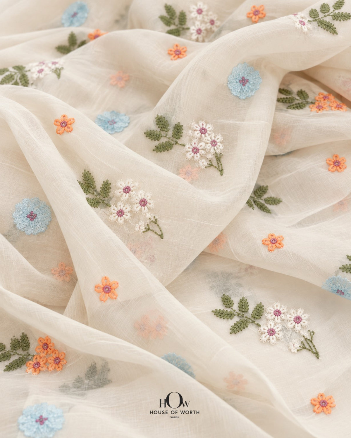 Close-up of ivory Mul Chanderi with powder blue, peach and ivory flowers and olive-green sprigs