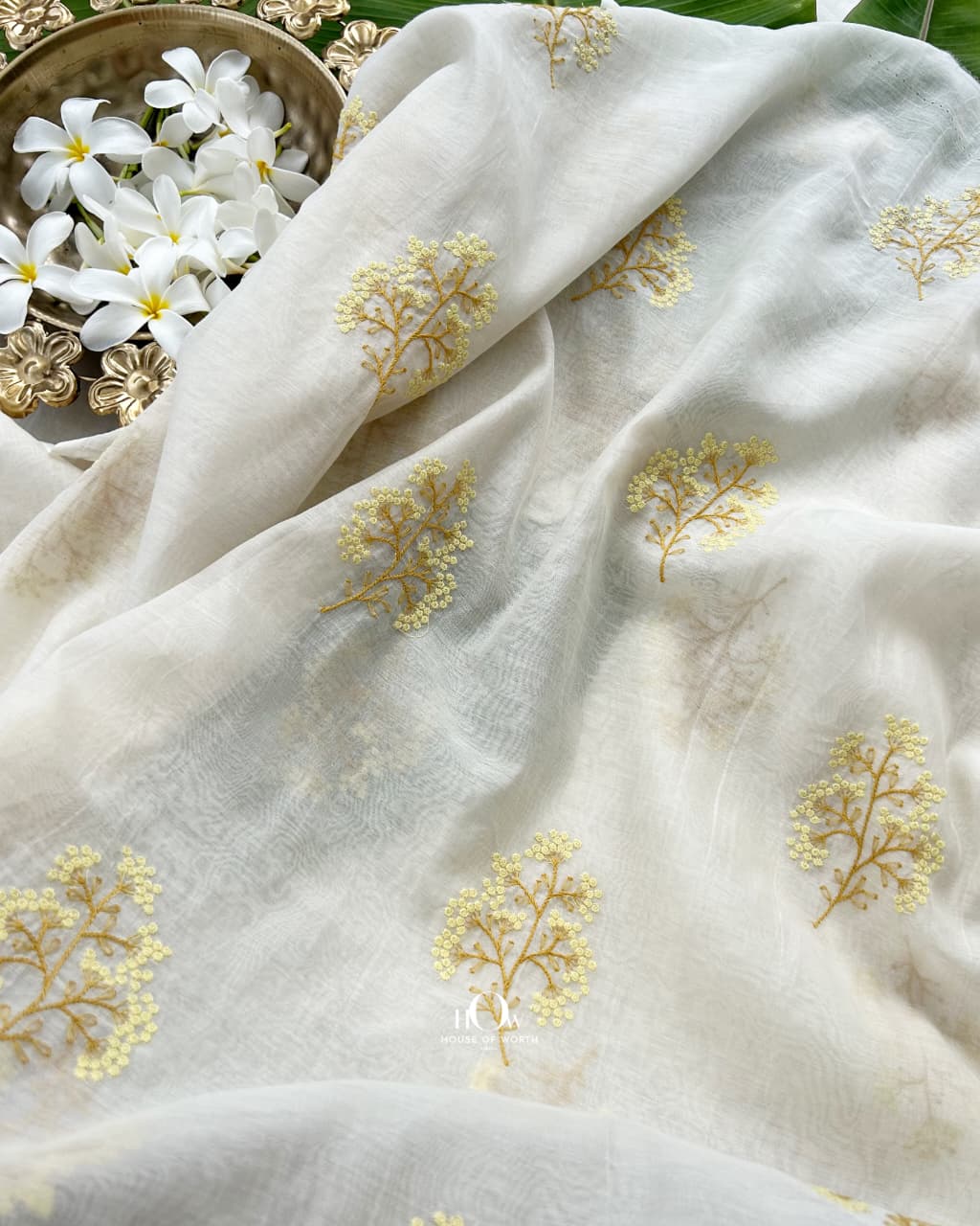 Close view of yellow and mustard botanical embroidery on elegant Mul Chanderi fabric