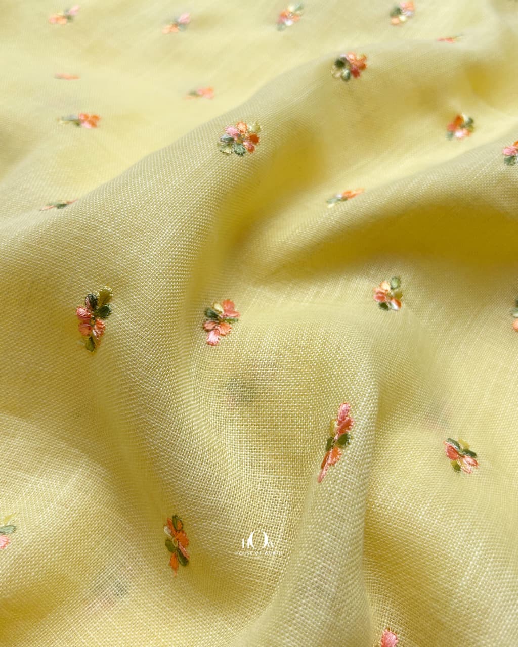 Butter yellow cotton linen fabric with elegant floral embroidery, perfect for luxe ethnic garments.