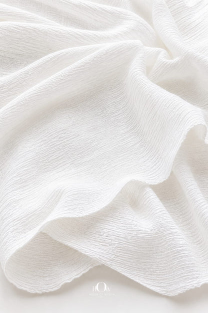 Crinkled cotton fabric draped elegantly—lightweight, breathable 100% cotton material for dresses
