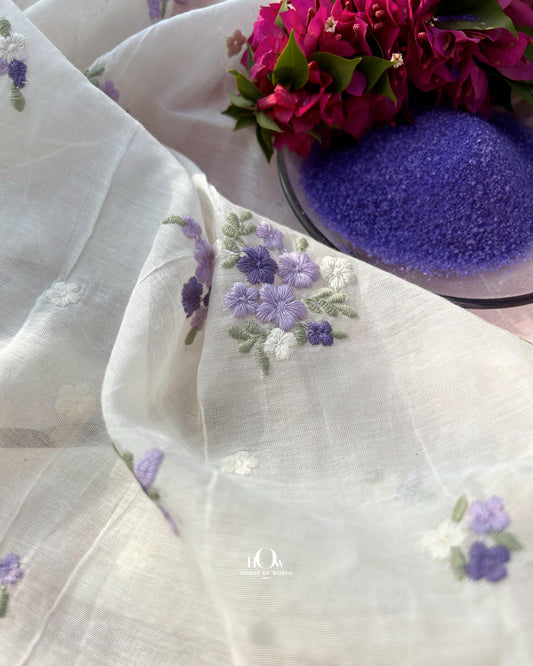 Pure dyeable Mul Chanderi fabric in off-white with purple and blue floral butti embroidery – ideal for suits, sarees, and dupattas.