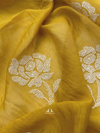 Bright yellow Mul Chanderi fabric with white floral embroidery – perfect for festive sarees, suits, and ethnic wear.