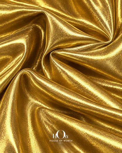 Golden shiny metallic Lycra fabric drape for dresses, stagewear and statement fashion