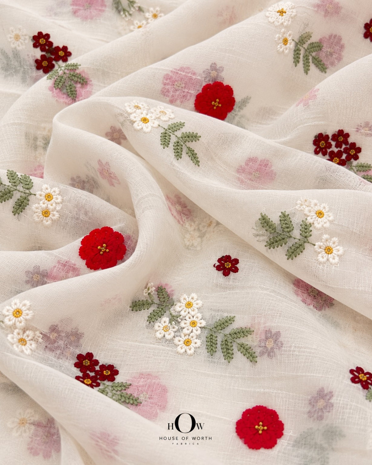 Draped ivory Mul Chanderi showing scattered red florals, ivory blooms and soft green botanical motifs