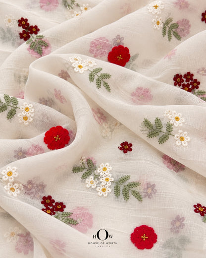 Draped ivory Mul Chanderi showing scattered red florals, ivory blooms and soft green botanical motifs