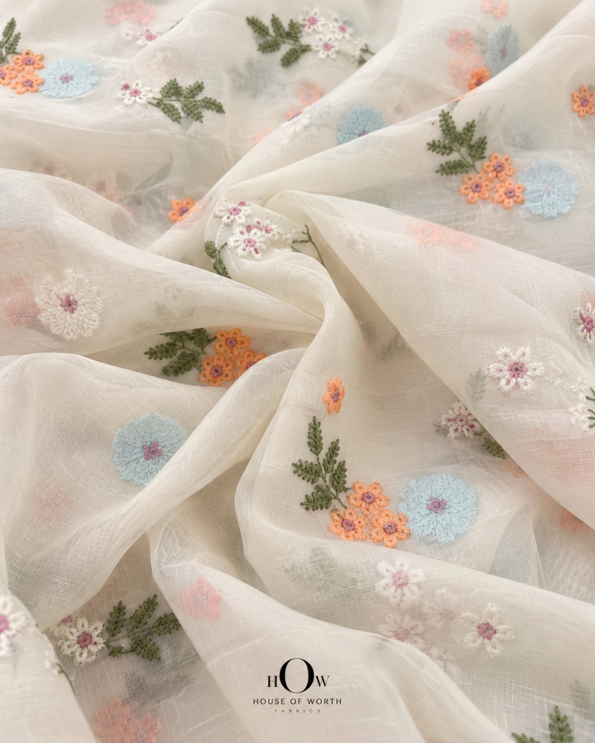 Lightly draped ivory Pure Mul Chanderi showing spaced multicolour floral embroidery and botanical motifs