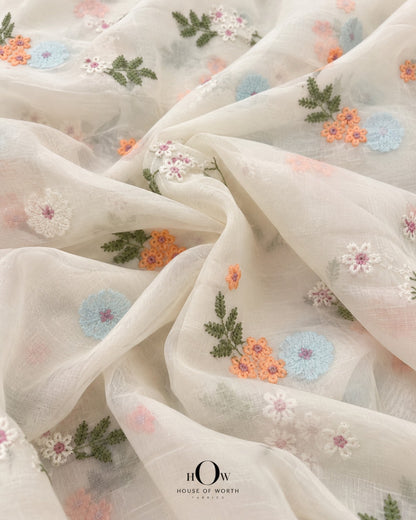 Lightly draped ivory Pure Mul Chanderi showing spaced multicolour floral embroidery and botanical motifs