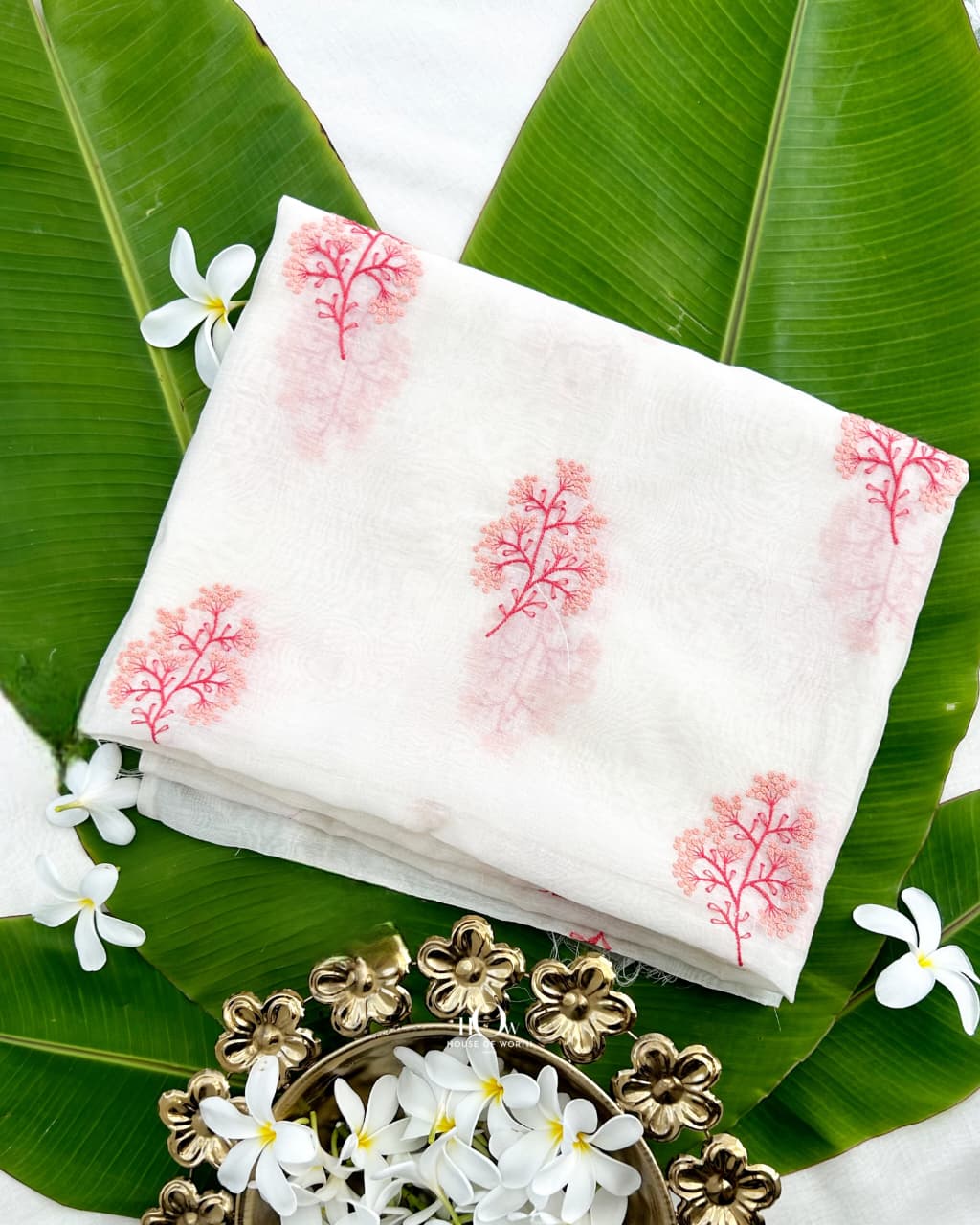 Coral pink floral sprigs with red stems on ivory Kasavu Pure Mul Chanderi fabric