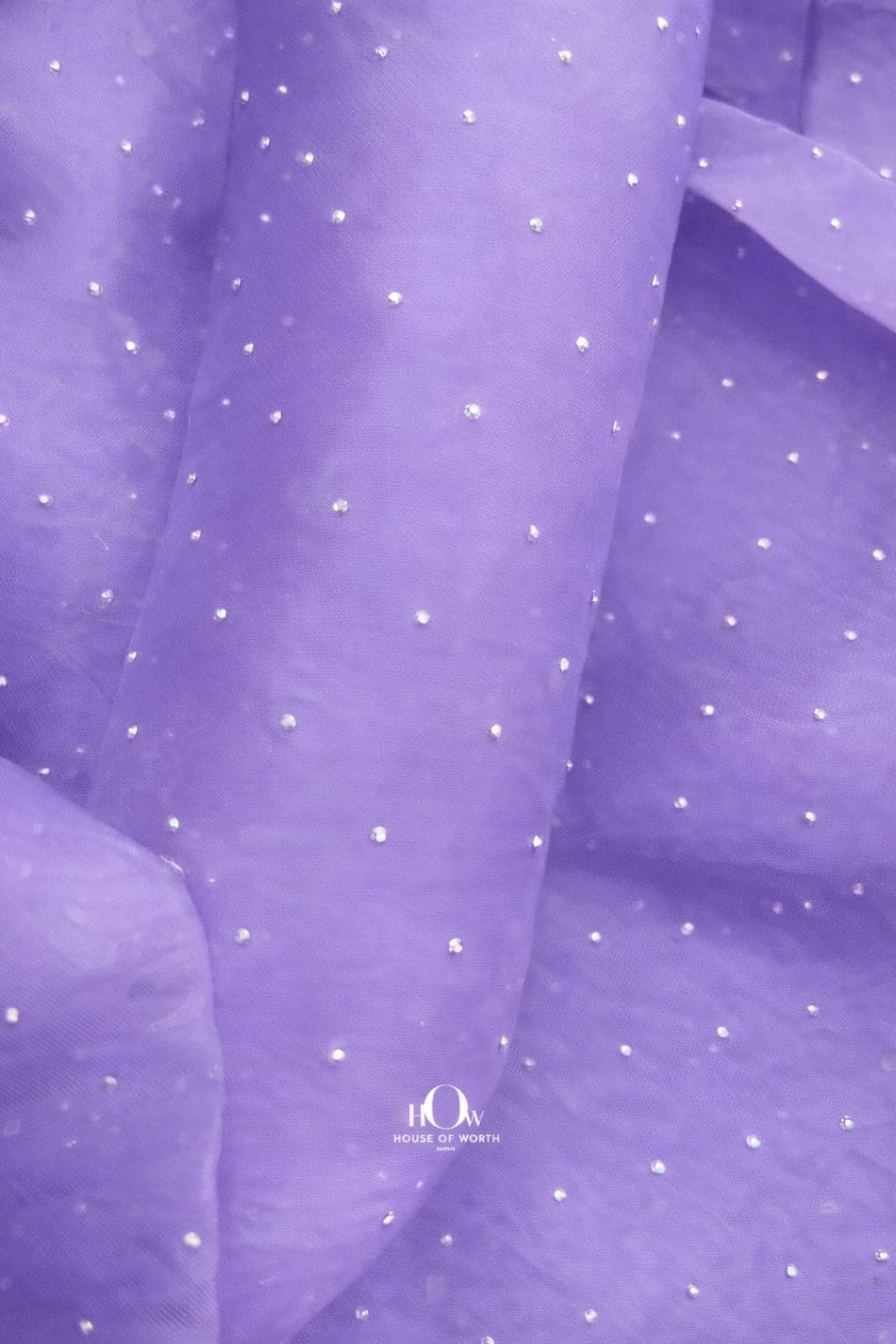 Close-up of pastel lilac organza material with glittering rhinestone details