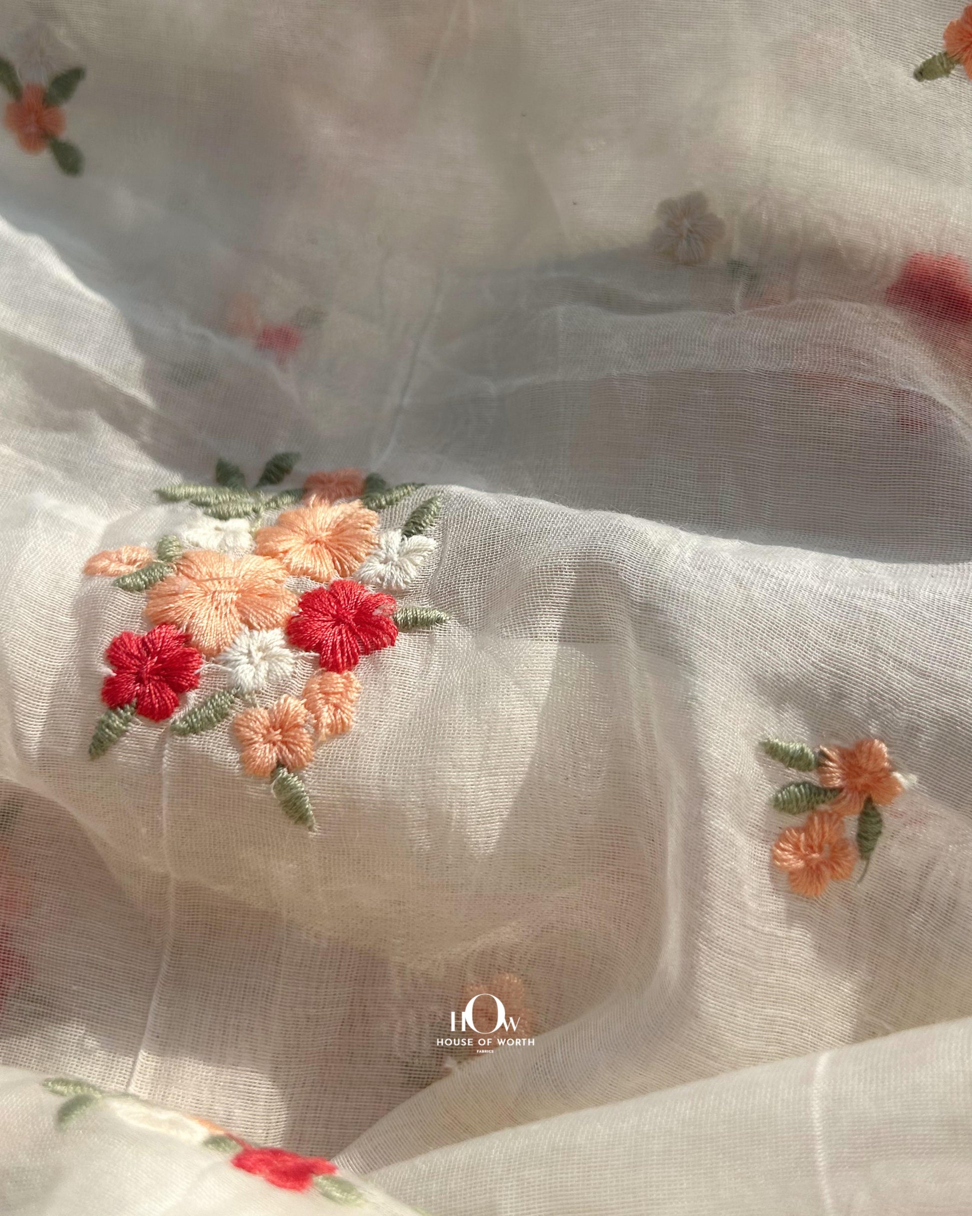 Off-white dyeable Chanderi fabric with small red floral embroidery – suitable for boutique collections and festive tailoring.