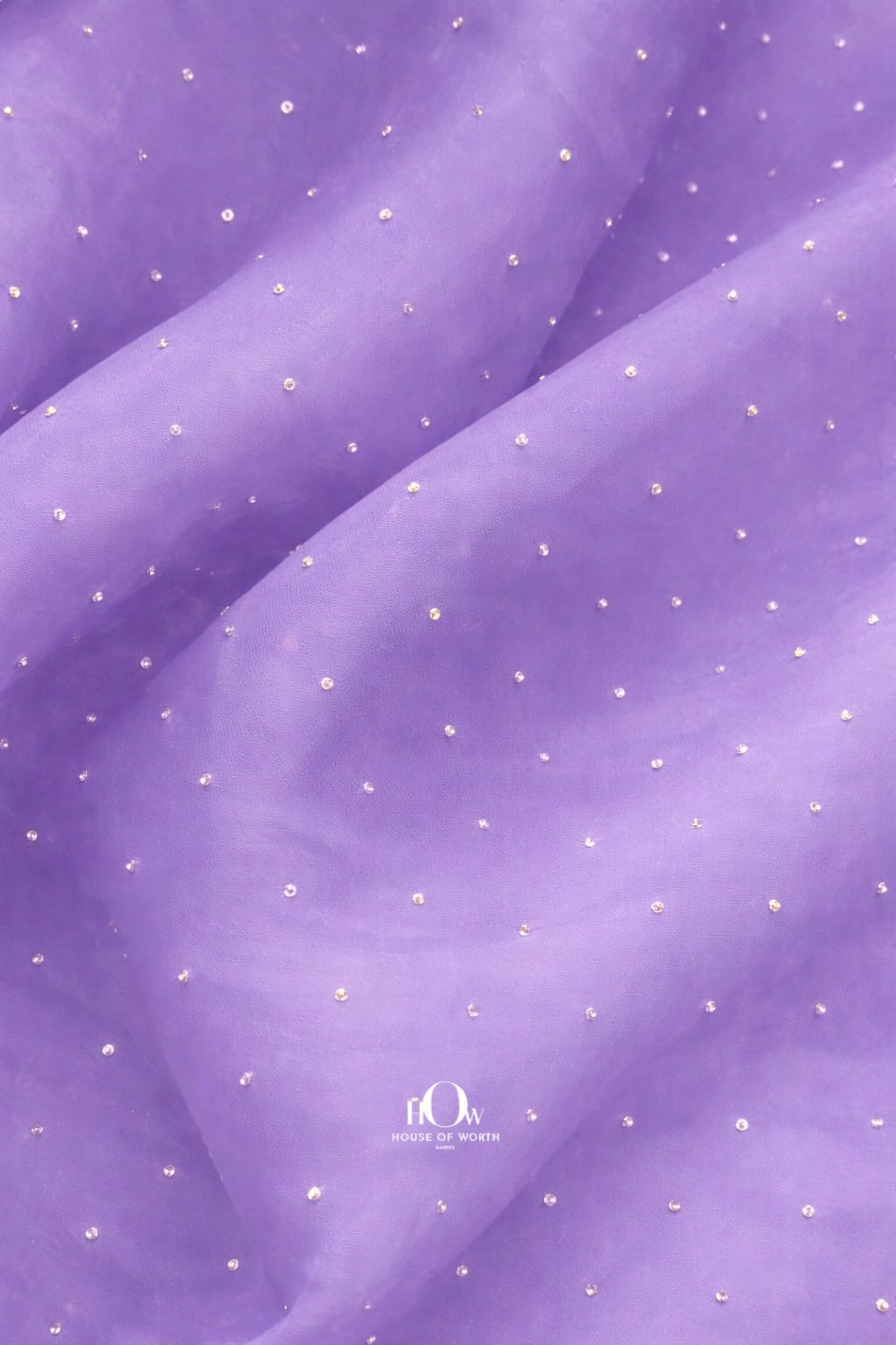 Lilac organza fabric adorned with delicate rhinestones for an elegant look