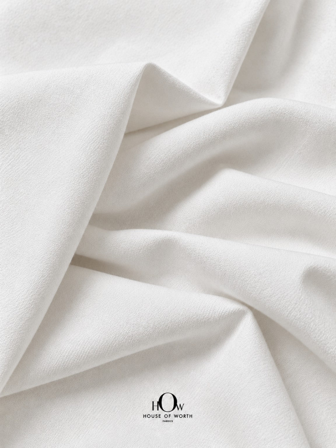 Draped white dyeable denim fabric with structured folds and a clean plain finish