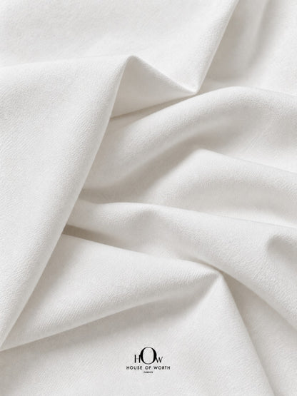 Draped white dyeable denim fabric with structured folds and a clean plain finish