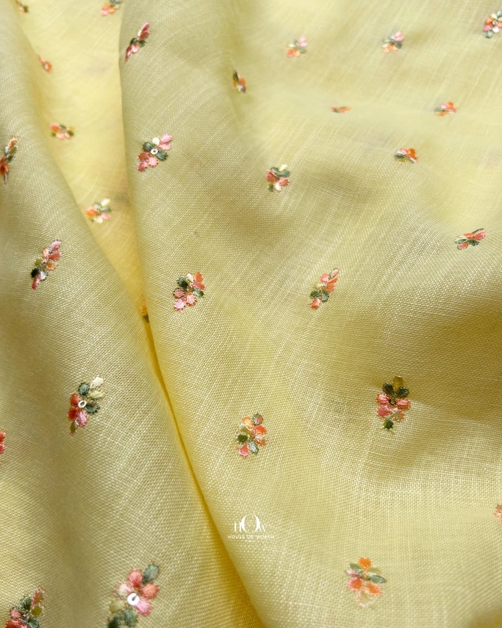Breathable butter-hued cotton-linen fabric embroidered with flowers, suitable for high-end Indo-western wear.