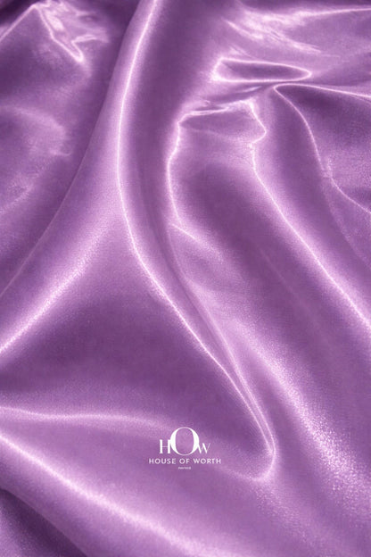 Heavy satin fabric with smooth texture and pastel purple sheen