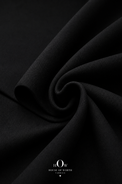 Close-up of black Scuba Sandwich Fabric showing its smooth-looking surface and neat solid finish