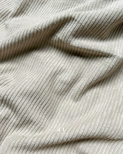 Solid beige corduroy fabric with visible ribbed lines for jackets, shirts and trousers