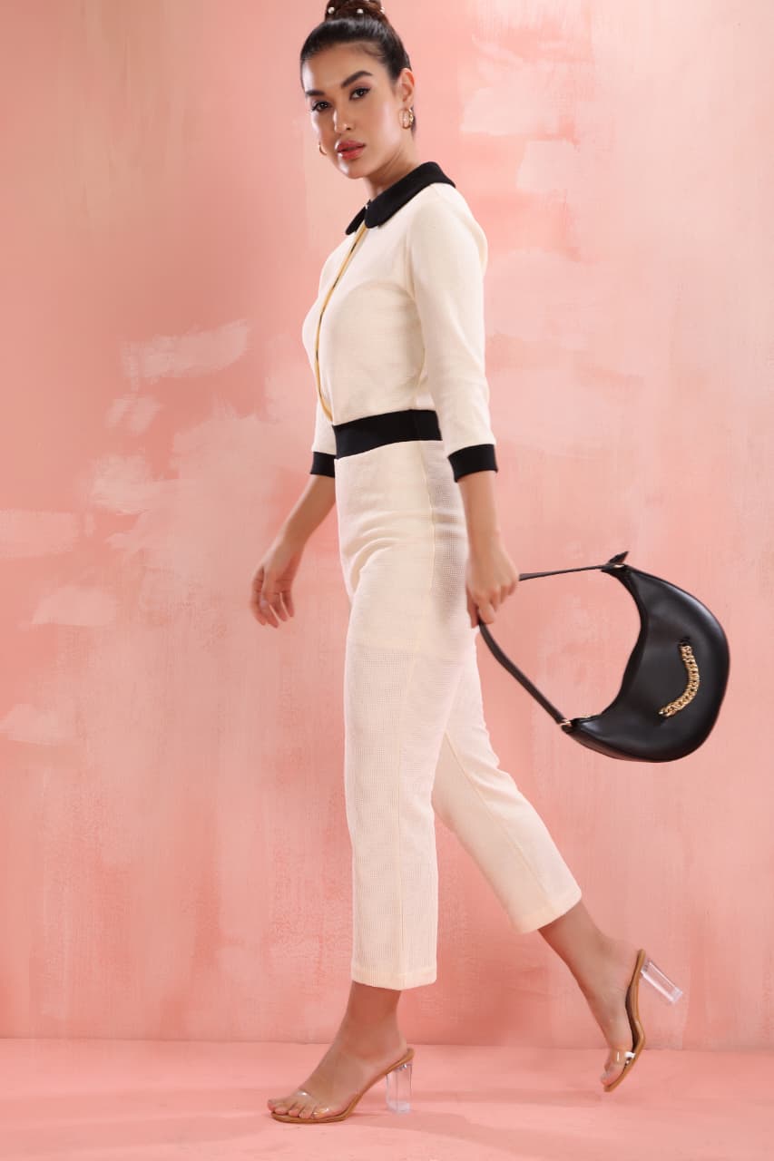 Stylish cream knit jumpsuit for women with black collar and fitted waist design